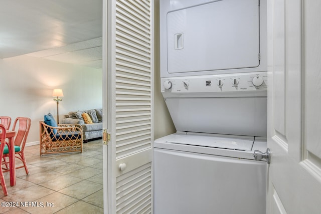 laundry area featuring stacked washing maching and dryer and light tile floors