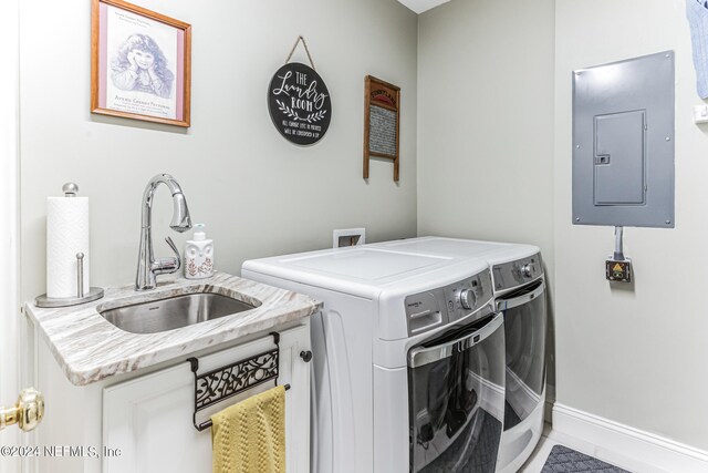 clothes washing area featuring washer and clothes dryer, tile floors, and sink