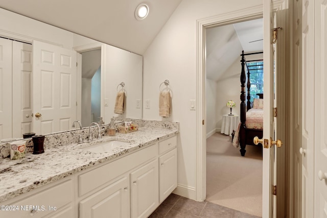bathroom featuring tile flooring, vanity, and lofted ceiling