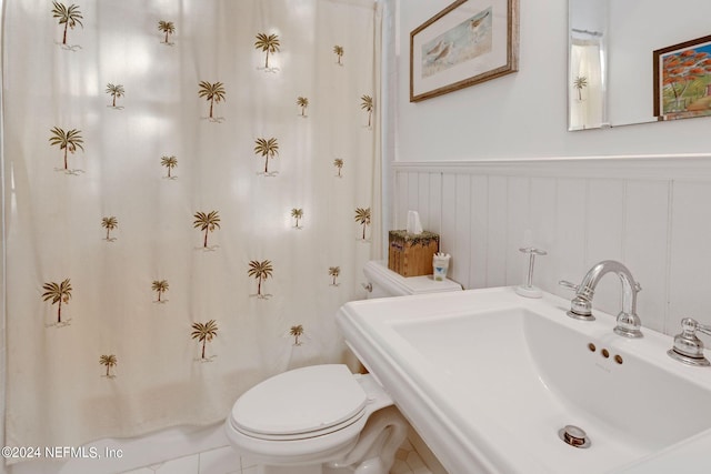 bathroom featuring sink, tile floors, and toilet