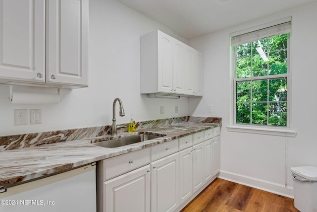 kitchen with white cabinets, light stone countertops, dark wood-type flooring, and sink