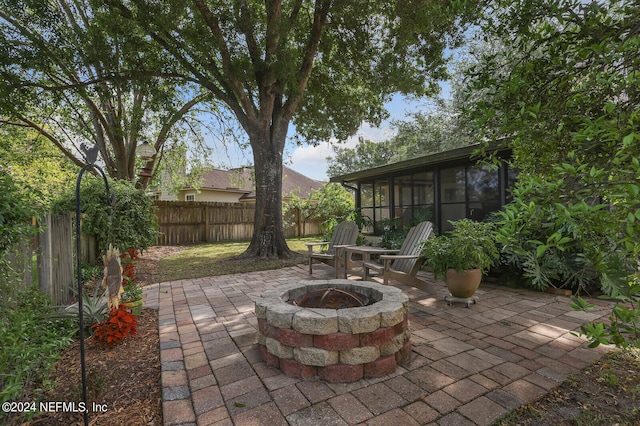 view of patio / terrace with a fire pit and a sunroom