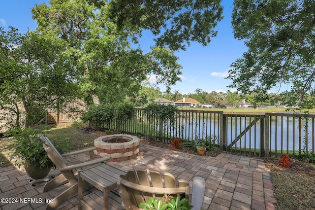 view of patio with a water view and a fire pit