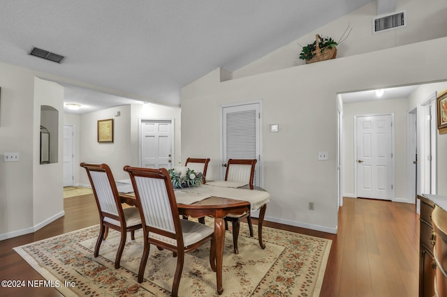 dining room with dark hardwood / wood-style flooring and vaulted ceiling