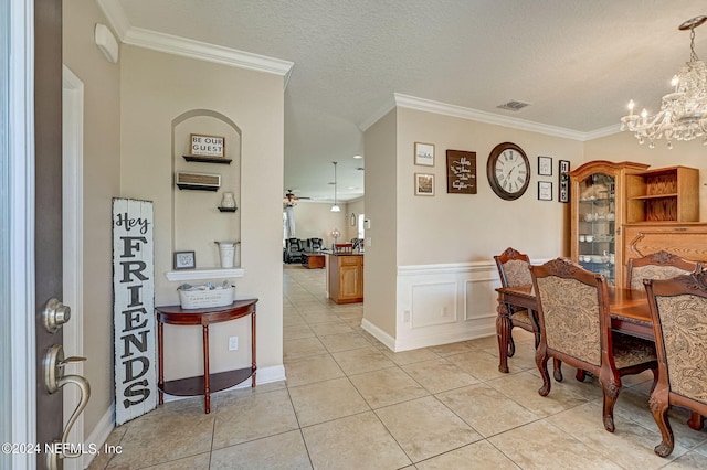 tiled dining room with ornamental molding, a textured ceiling, and ceiling fan with notable chandelier