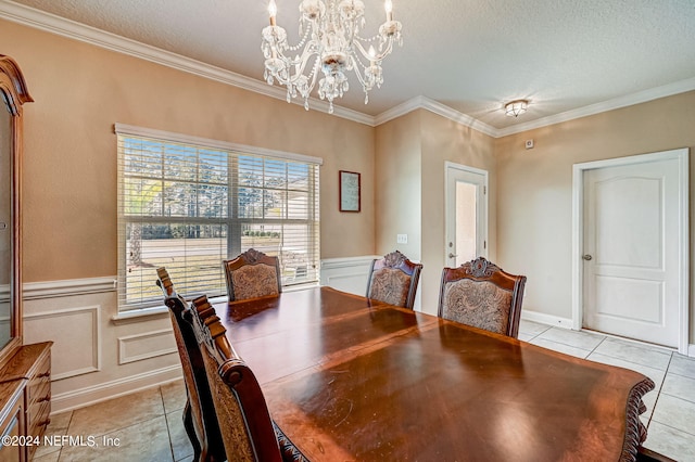 tiled dining area with a chandelier, a textured ceiling, and crown molding