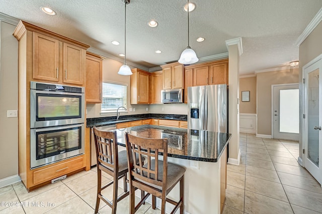 kitchen with stainless steel appliances, light tile flooring, decorative light fixtures, and a center island