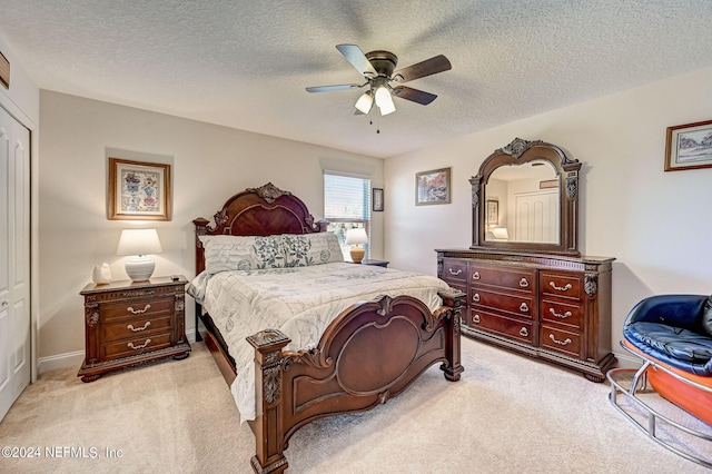 carpeted bedroom featuring a textured ceiling and ceiling fan