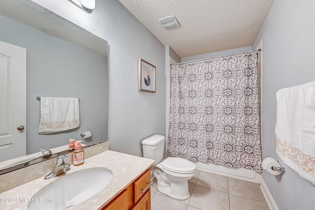 bathroom featuring a textured ceiling, tile floors, toilet, and vanity