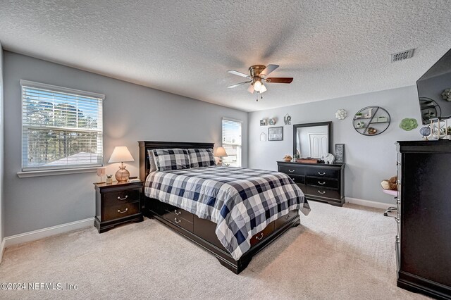 carpeted bedroom featuring a textured ceiling and ceiling fan