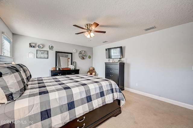 carpeted bedroom with a textured ceiling and ceiling fan