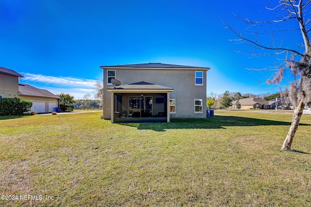 back of property with a yard, a sunroom, and a garage