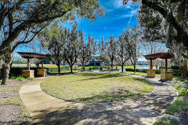 view of nearby features with a pergola and a lawn