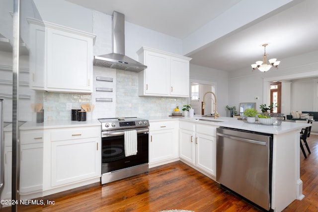 kitchen with dark hardwood / wood-style floors, stainless steel appliances, sink, and wall chimney range hood