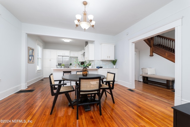 dining area featuring an inviting chandelier, wood-type flooring, and sink