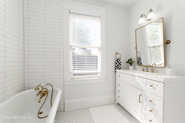 bathroom featuring tile floors, vanity, and a washtub