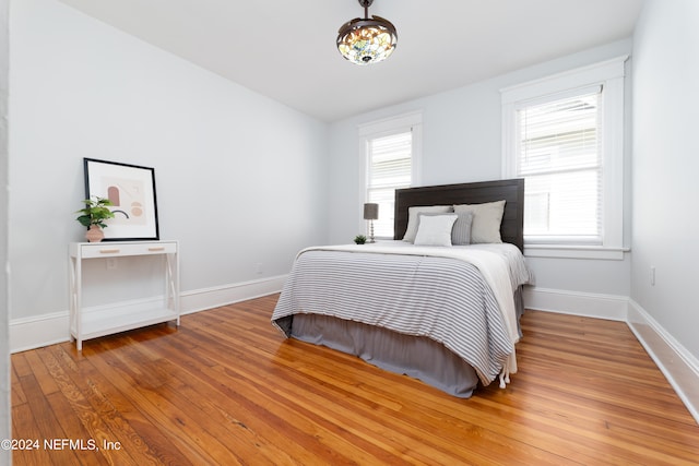 bedroom featuring light hardwood / wood-style flooring and a chandelier