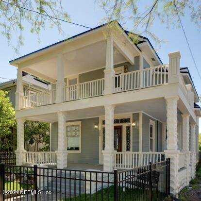 rear view of property featuring a balcony and covered porch