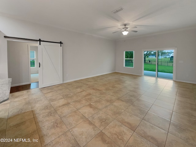 empty room featuring a barn door, ceiling fan, and light tile floors