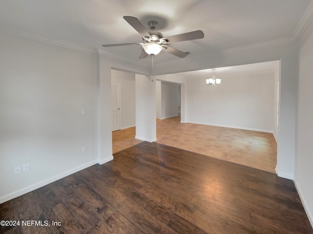 empty room featuring crown molding, dark hardwood / wood-style flooring, and ceiling fan with notable chandelier