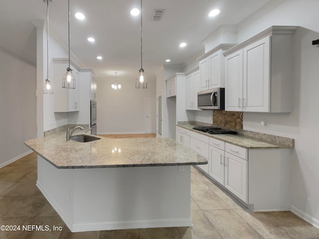 kitchen featuring pendant lighting, sink, white cabinets, stainless steel appliances, and light stone countertops