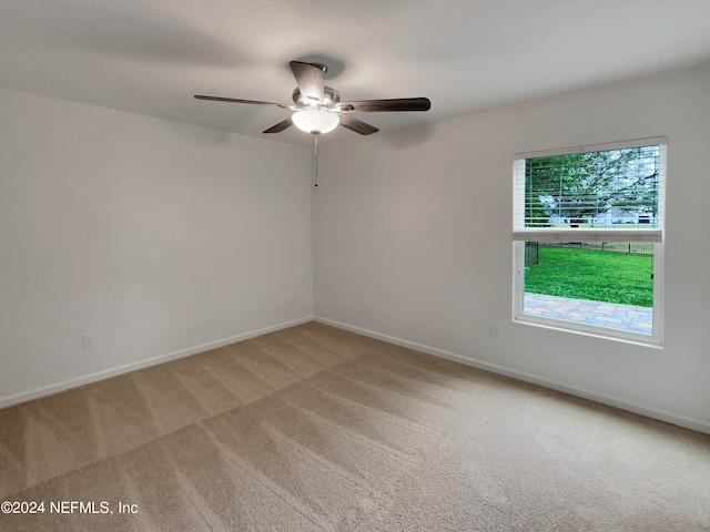 spare room featuring ceiling fan and light colored carpet