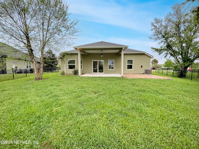 rear view of house featuring central AC, a lawn, and a patio area