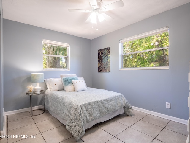 bedroom with ceiling fan, multiple windows, and light tile patterned floors