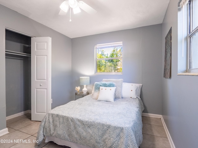 bedroom featuring light tile patterned flooring, a closet, and ceiling fan