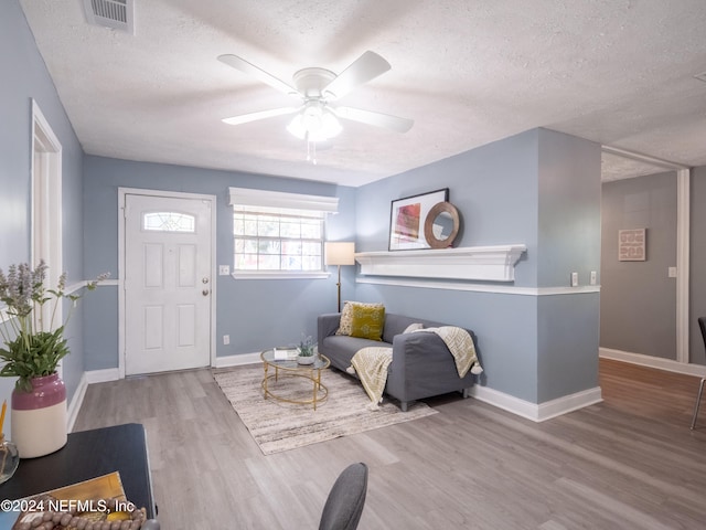 sitting room with a textured ceiling, ceiling fan, and light hardwood / wood-style floors