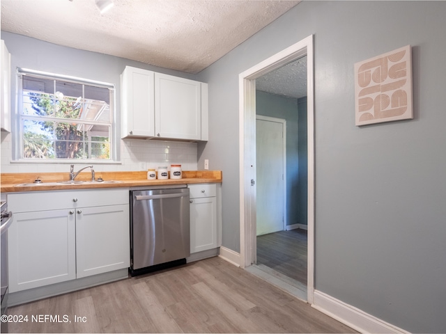 kitchen with butcher block counters, white cabinets, a textured ceiling, dishwasher, and backsplash