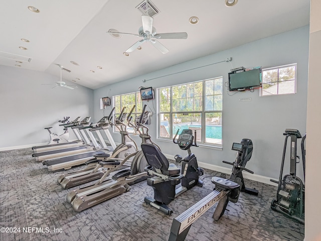 exercise room featuring vaulted ceiling, ceiling fan, and carpet floors