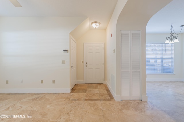 foyer featuring ceiling fan with notable chandelier