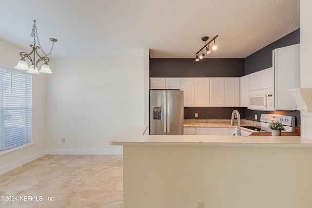 kitchen featuring a textured ceiling, a notable chandelier, white cabinets, rail lighting, and white appliances