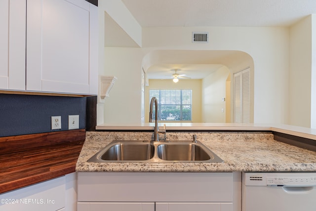 kitchen featuring white cabinets, light stone countertops, dishwasher, ceiling fan, and sink