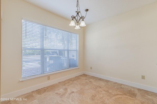 spare room with a notable chandelier