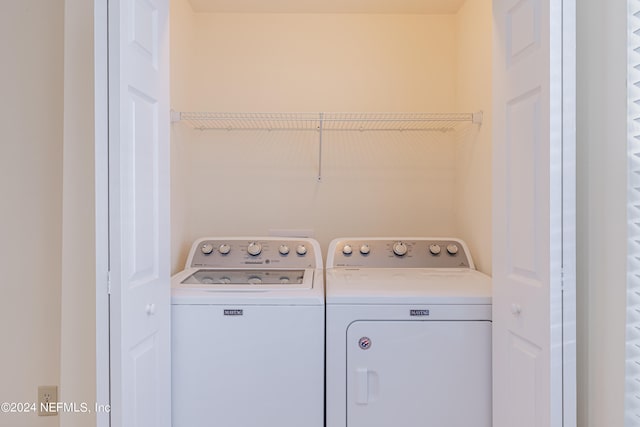 clothes washing area with washing machine and dryer