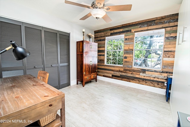 home office with wood walls and ceiling fan