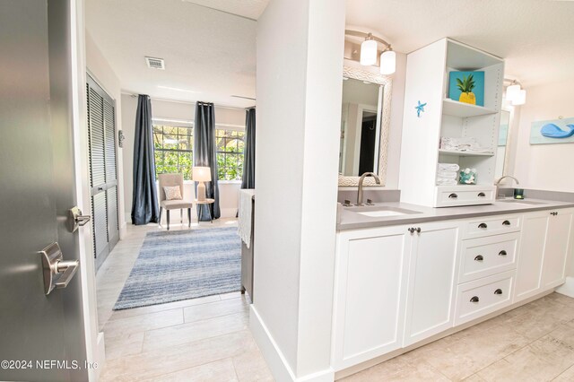 bathroom featuring tile floors and dual bowl vanity