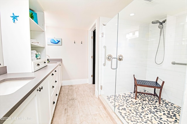 bathroom with double sink vanity, walk in shower, and hardwood / wood-style flooring