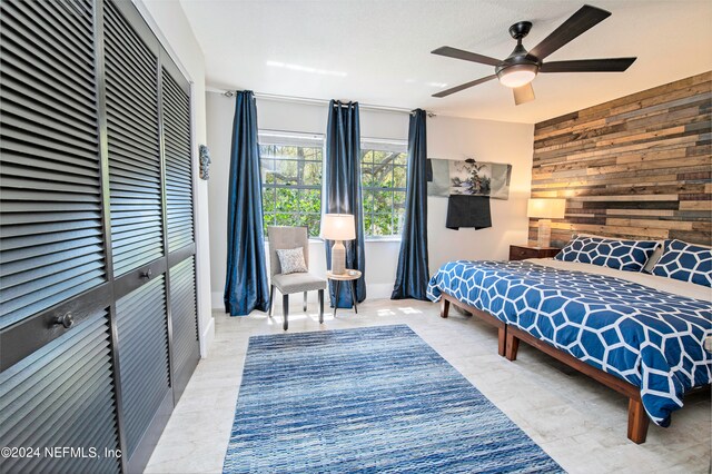 tiled bedroom with ceiling fan and wooden walls