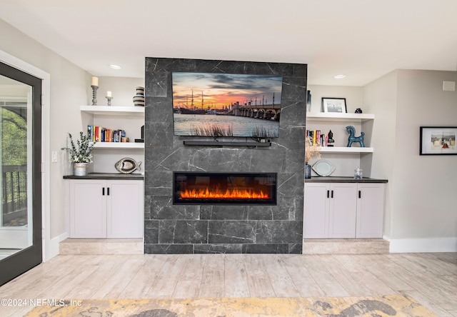 unfurnished living room with light hardwood / wood-style floors and a tile fireplace