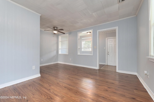 unfurnished room with dark wood-style floors, ornamental molding, and baseboards