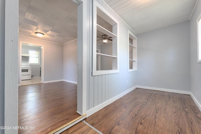 empty room featuring a ceiling fan, wood finished floors, built in features, and baseboards