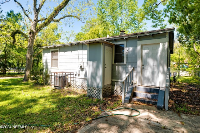 view of outdoor structure featuring entry steps, central AC unit, and an outdoor structure