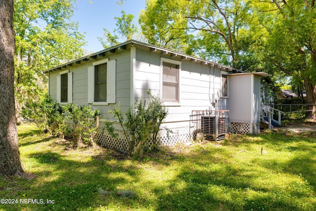 view of outbuilding featuring central AC and fence