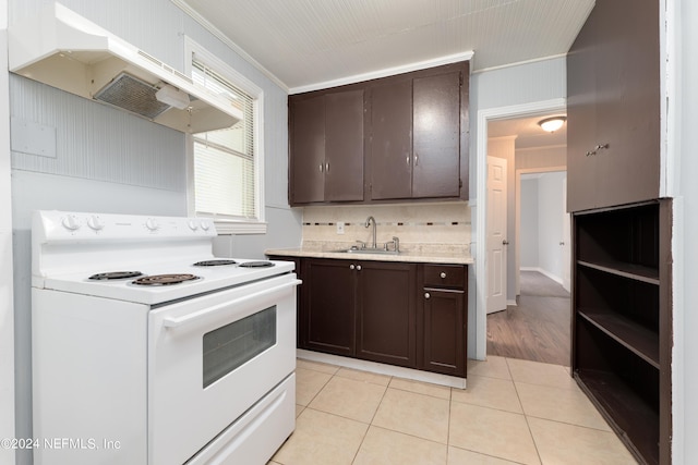 kitchen with white electric stove, light tile patterned floors, a sink, dark brown cabinets, and premium range hood