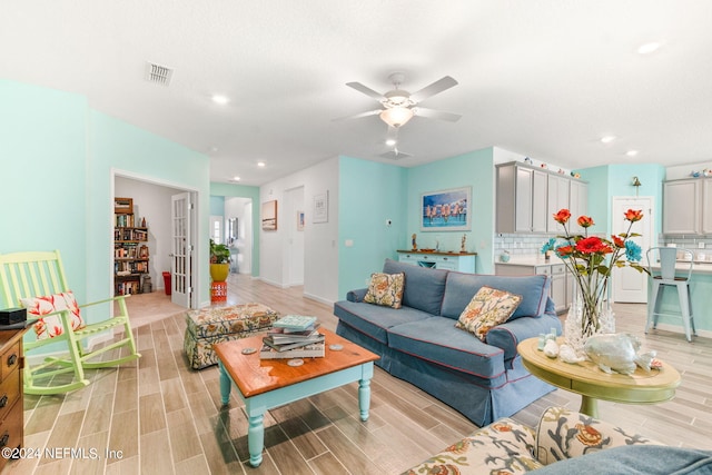 living room with light hardwood / wood-style flooring and ceiling fan