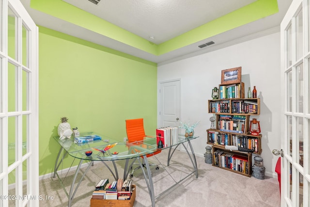 carpeted home office with a raised ceiling