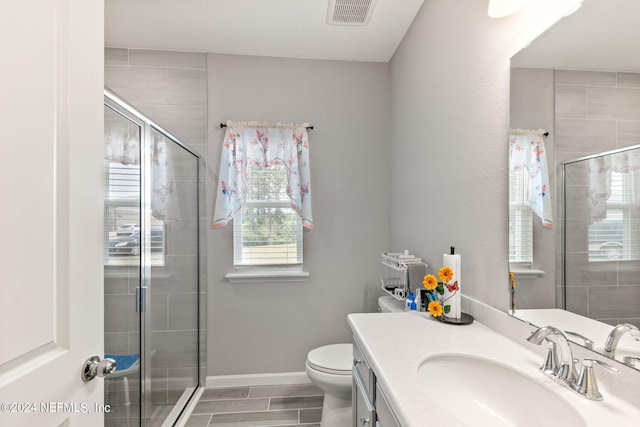 bathroom with vanity, toilet, and a shower with shower door